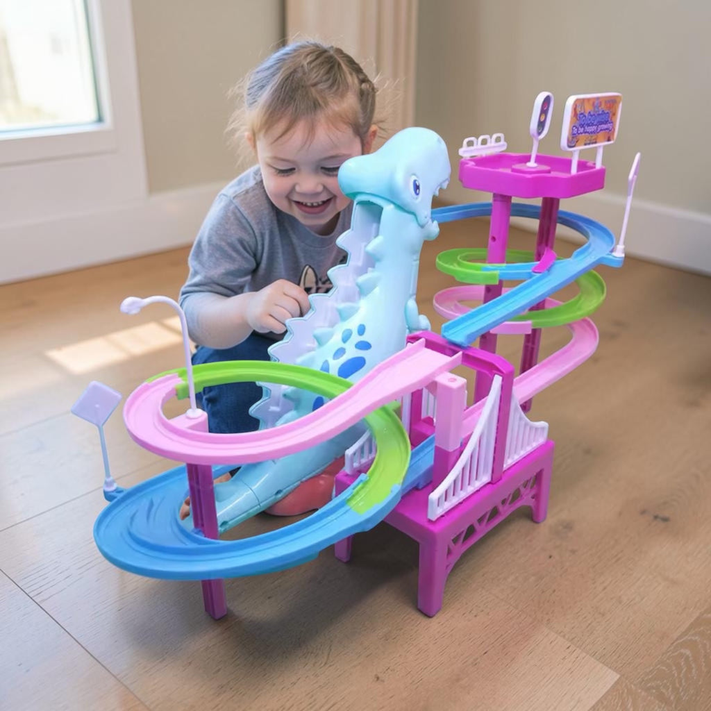 A young child smiling and playing with a colorful toy dinosaur roller coaster on a light wood floor in a bright room.