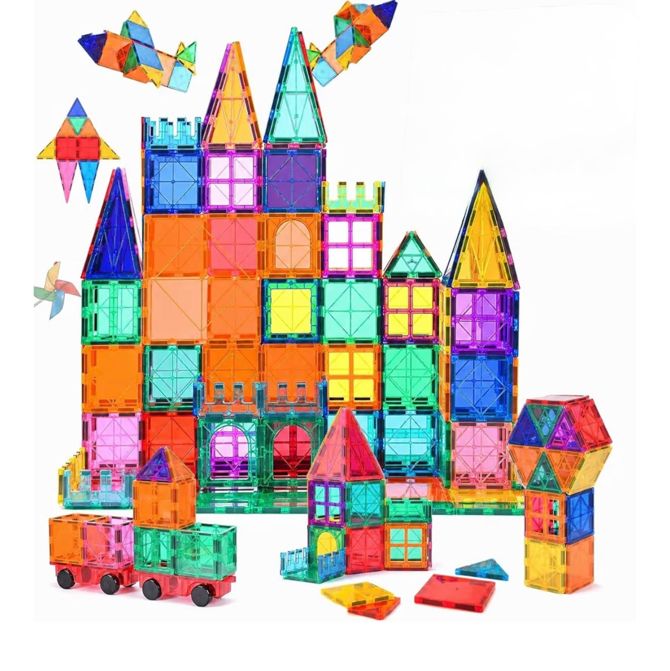 A set of colorful transparent magnetic building blocks arranged to form a castle and small toy vehicles on a plain white background.