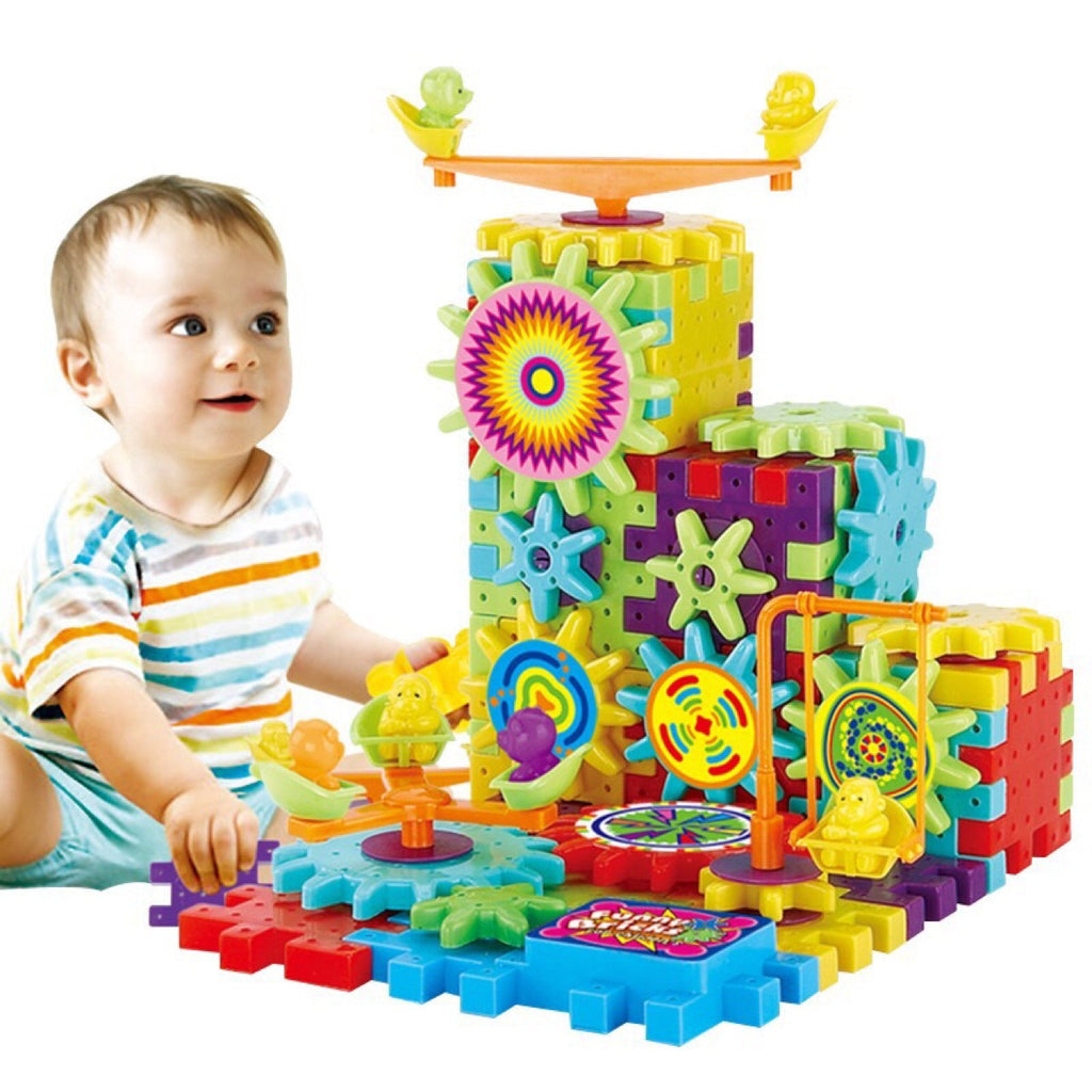 Child playing with a colorful toy set of interlocking gears on a white background